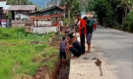 TEKS : Puluhan warga gampong Baharu, Blangpidie bekerja membersihkan saluran pembuang air, Jum'at (19/11/2021). FOTO : GLOBAL/SALMAN