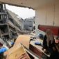 Seorang wanita Palestina duduk di atas puing-puing apartemennya yang rusak di distrik Khezaa di pinggiran kota Khan Yunis di Jalur Gaza selatan, setelah berminggu-minggu pemboman Israel, ketika gencatan senjata antara Israel dan Hamas memasuki hari kedua pada 25 November 2023. (AFP)