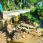 Salah seorang warga berada di lokasi saluran irigasi yang putus di gampong Gudang, Kecamatan Blangpidie, Abdya, Senin (27/11/2023). Foto : Acehglobal/Halimi.